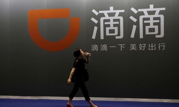 FILE PHOTO - A woman walks past Didi Chuxing's booth at the Global Mobile Internet Conference (GMIC) 2017 in Beijing, China April 28, 2017. REUTERS/Jason Lee

