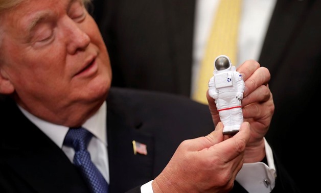 U.S. President Donald Trump holds a space astronaut toy as he participates in a signing ceremony for Space Policy Directive at the White House in Washington D.C., U.S., December 11, 2017. REUTERS/Carlos Barria
