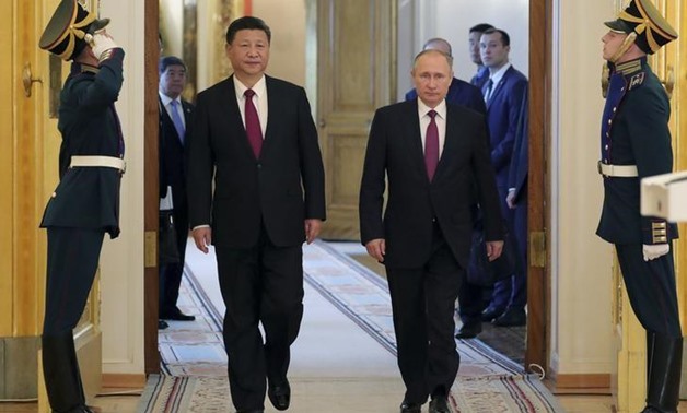 Russian President Vladimir Putin (R) and his Chinese counterpart Xi Jinping walk past honour guards during a meeting at the Kremlin in Moscow, Russia July 4, 2017. Sputnik/Mikhail Klimentyev/Kremlin via REUTERS