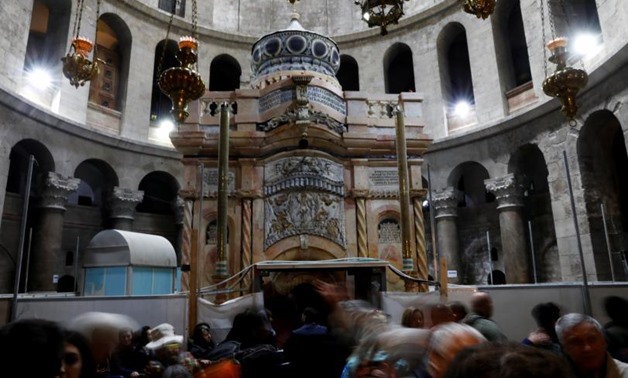 Visitors stand near the newly restored Edicule, the ancient structure housing the tomb, which according to Christian belief is where Jesus's body was anointed and buried, seen at the completion of months of restoration works, at the Church of the Holy Sep