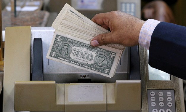 FILE- A bank employee counts U.S. dollar in a local bank 
