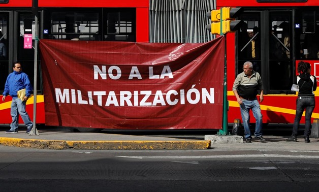 Activists hold a protest against a law that militarises crime fighting in the country outside the Senate in Mexico City, Mexico December 14, 2017. Baner reads, "No to the Militarisation in the Country". Picture taken December 14, 2017. REUTERS/Carlos Jass