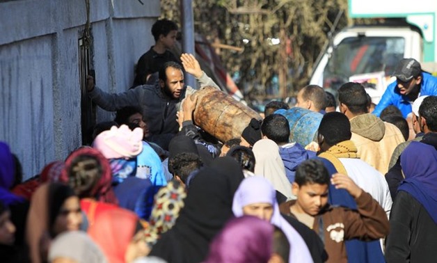 People wait in line to buy gas cylinders at a distribution point in Cairo, January 19, 2015 – Mohamed Abd El Ghany/Reuters