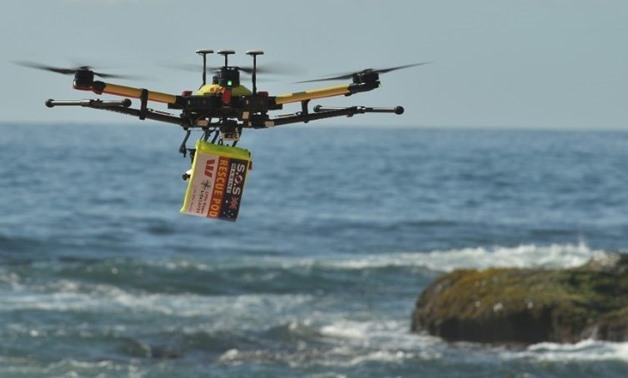 A shark-spotting drone with safety flotation device attached flies over Bilgola beach, Sydney – AFP