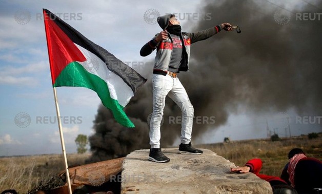 A protester palestino lanza piedras contra tropas israelíes cerca of the frontera of the Ciudad of Gaza. December 15, 2017 - REUTERS / Mohammed Salem