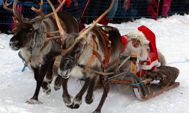 FILE PHOTO: Santas from Sweden (R) and Russia race on their sleighs pulled by reindeers during a competition in the Santa Claus Wintergames in northern Swedish town of Gallivare, November 20, 2005. REUTERS/Pawel Kopczynsk