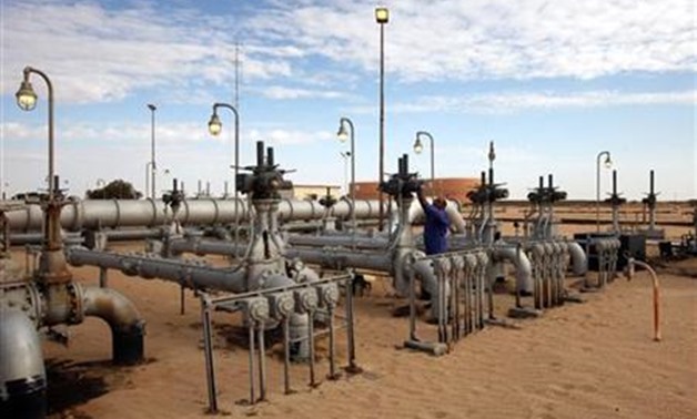 A worker checks pipes and valves at Amaal oil field in eastern Libya October 7, 2011. REUTERS/Ismail Zitouny
