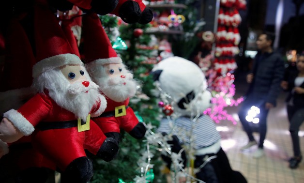 People look at Santa Claus toys outside a Christmas decoration shop on the eve of Christmas, while the capital is on high security alert, in Cairo, Egypt December 24, 2017. REUTERS/Amr Abdallah Dalsh