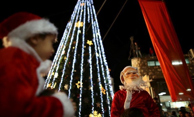 Boys wearing Santa Claus costumes are carried during a Christmas tree lighting ceremony in the northern town of Nazareth, the town of Jesus' boyhood, December 12, 2012. REUTERS/Ammar Awad