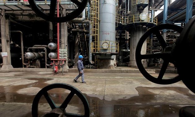 FILE PHOTO: A worker walks past oil pipes at a refinery in Wuhan, Hubei province March 23, 2012. REUTERS/Stringer/File Photo