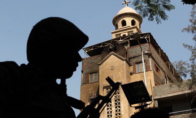 A soldier stands guard near the St. Mary Church, torched during sectarian clashes (Reuters)