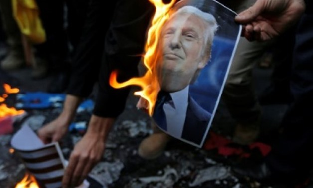 Iranian demonstrators burn a portrait of US President Donald Trump during a protest in Tehran on December 11, 2017 against his recognition of Jerusalem as Israel's capital
