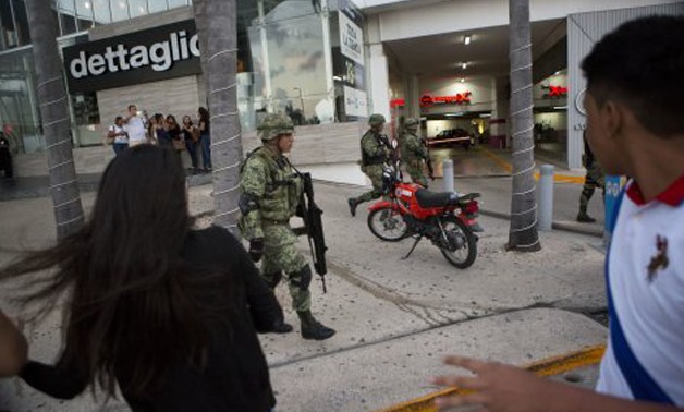 People react anxiously as soldiers patrol outside Plaza Las Americas mall after reports of gunfire, in Cancun, January 17, 2017.(AP Photo/Rebecca Blackwell)
