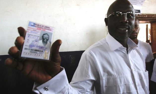 George Weah, former soccer player and presidential candidate of Congress for Democratic Change (CDC) shows his voter's card at a polling station in Monrovia, Liberia October 10, 2017. REUTERS/Thierry Gouegnon