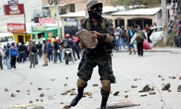 Stringer, AFP | A soldier removes stones after clashes with supporters of the Honduran Opposition Alliance Against the Dictatorship in Tegucigalpa on January 20, 2018.
