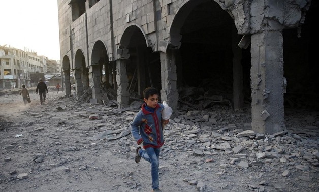 A Syrian boy runs past a damaged building in Douma, in the eastern Damascus suburb of Ghouta, Syria November 15, 2017. REUTERS/Bassam Khabieh

