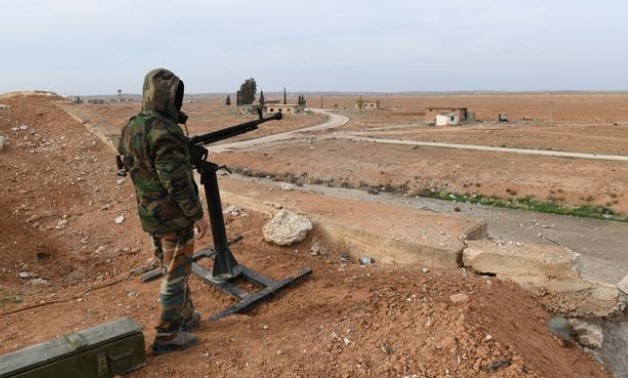FILE PHOTO - A Syrian Army soldier loyal to Syria's President Bashar al-Assad forces stands next to a military weapon in Idlib, Syria January 21, 2018. Picture taken January 21, 2018. SANA/Handout via REUTERS