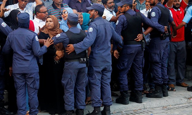Maldivian Police officers push back the opposition supporters near the main opposition Maldives Democratic Party (MDP) headquarters during a protest demanding the government to release jailed opposition leaders, including former Presidents Mohamed Nasheed