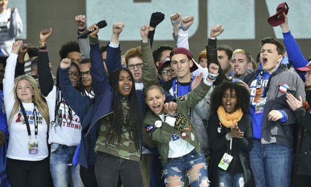 Marjory Stoneman Douglas High School student Emma Gonzalez (C) gathers with other students on stage during the March for Our Lives rally - AFP 