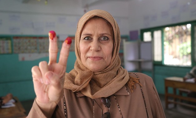 A woman poses for the camera after voting in the Workers University in Cairo on March 28, 2018 - Mohamed el-Hosary
