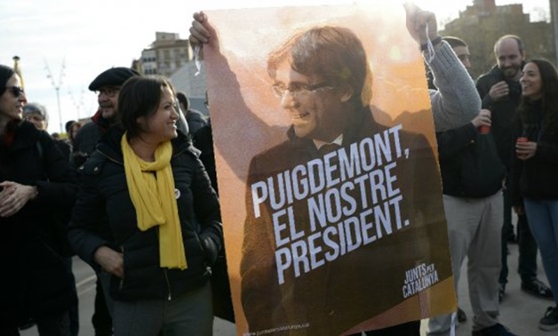 A protester holds a poster of Catalonia's former president Carles Puigdemont reading "Our president" during a demonstration calling for his release outside the Barcelona-Sants train station on March 27, 2018. - Josep Lago, AFP