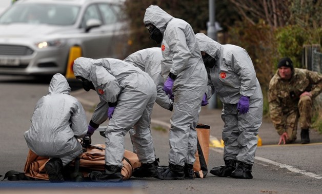 British Military personnel wearing protective coveralls work to remove a vehicle connected to the March 4 nerve agent attack in Salisbury, southeast England on March 14, 2018 – AFP/Adrian Dennis