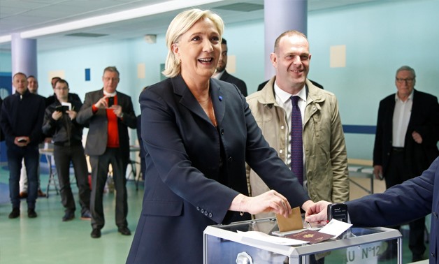 Marine Le Pen (L), French National Front (FN) political party leader and candidate for French 2017 presidential election, casts her ballot in the first round of 2017 French presidential election at a polling station in Henin-Beaumont, northern France, Apr