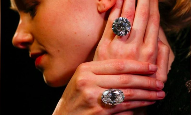 A model poses with two white diamonds, each over 50 carats, at Sotheby's auction house in London, Britain, April 6, 2018. REUTERS/Henry Nicholls
