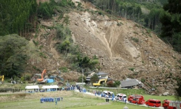 © JIJI PRESS/AFP | Rescue workers and police search for survivors at the scene of a landslide that hit residential homes in Nakatsu