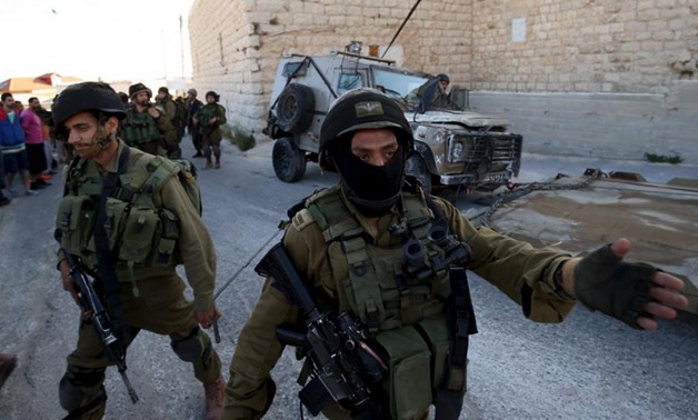An Israeli soldier gestures during confrontations with Palestinians in Qafr Malik village near the West Bank city of Ramallah June 14, 2015. REUTERS/Mohamad Torokman