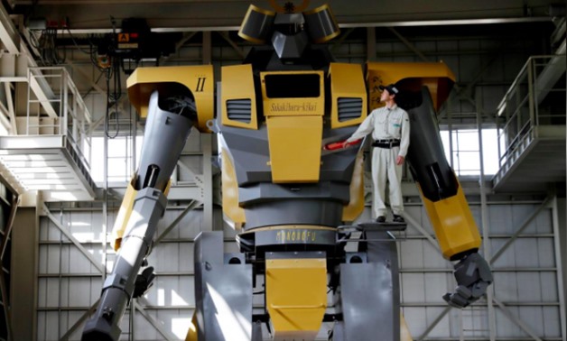 Sakakibara Kikai's engineer Go Sakakibara poses with the bipedal robot Mononofu during its demonstration at its factory in Shinto Village, Gunma Prefecture, Japan, April 12, 2018. REUTERS/Kim Kyung-Hoon

