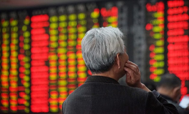 An investor looks at an electronic board showing stock information at a brokerage house in Nanjing, Jiangsu province, China April 16, 2018. REUTERS/Stringer