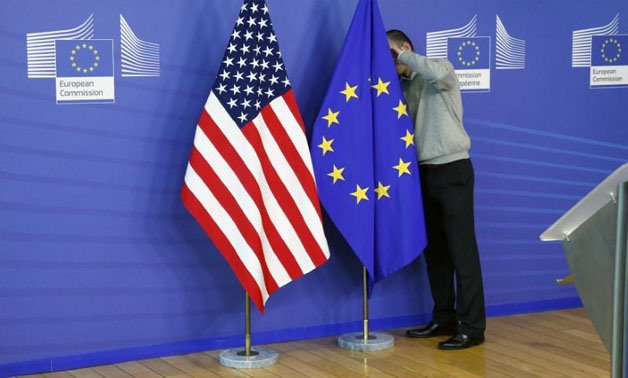  A worker adjusts European Union and U.S. flags at the start of the 2nd round of EU-US trade negotiations for Transatlantic Trade and Investment Partnership at the EU Commission headquarters in Brussels November 11, 2013. REUTERS/Francois Lenoir