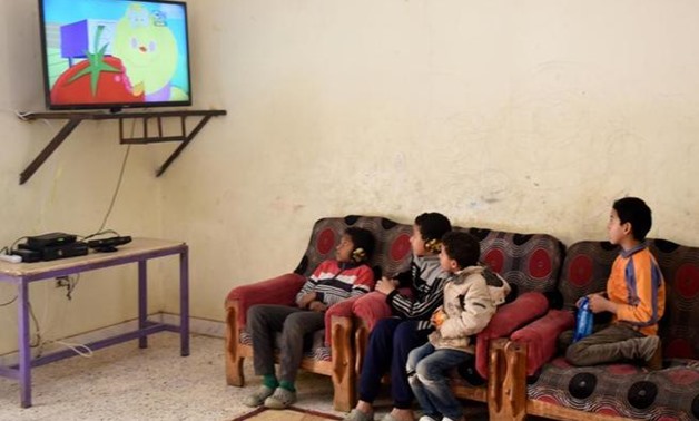 Children watching TV - AFP