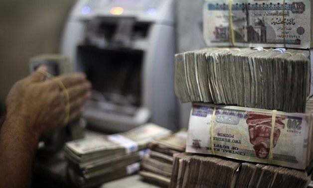 FILE- An employee counts money at an exchange office in downtown Cairo (Photo credit: Reuters/Amr Abdallah Dalsh)