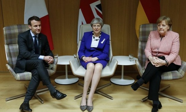 Britain's Prime Minister Theresa May is flanked by French President Emmanuel Macron and German Chancellor Angela Merkel before their trilateral meeting at the European Union leaders summit in Brussels, Belgium, March 22, 2018. REUTERS/Francois Lenoir/File