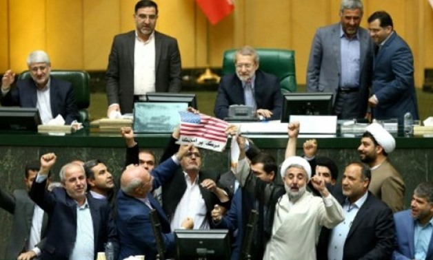 © Islamic Consultative Assembly News Agency/AFP | A handout picture from the Iranian Parliament shows MPs preparing to burn a US flag in the parliament's chamber in Tehran on May 9, 2018
