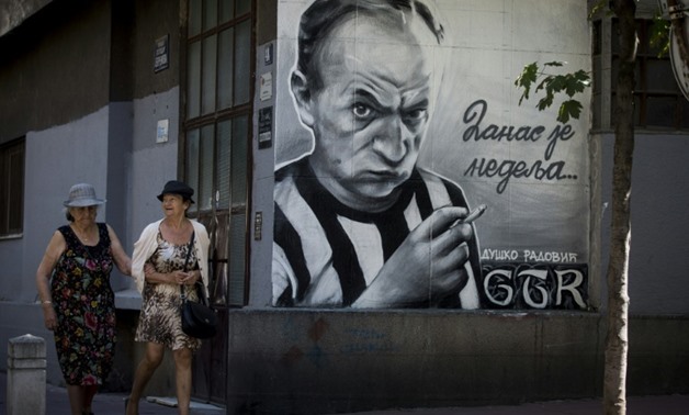Graffiti artists from the Grobarski Trash Romantizam (GTR) group depict famous Serbian poet and Partizan soccer club fan Dusko Radovic on a Blegrade wall-AFP / OLIVER BUNIC

