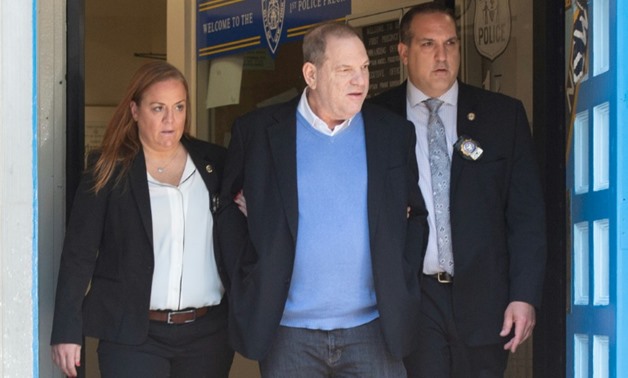 Harvey Weinstein, center, was led out of the New York City Police Department's First Precinct in handcuffs
