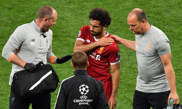  Liverpool's Egyptian forward Mohamed Salah (C) gets medical assistance as he leaves the pitch following injury during the UEFA Champions League final football match between Liverpool and Real Madrid at the Olympic Stadium in Kiev, Ukraine on May 26, 2018