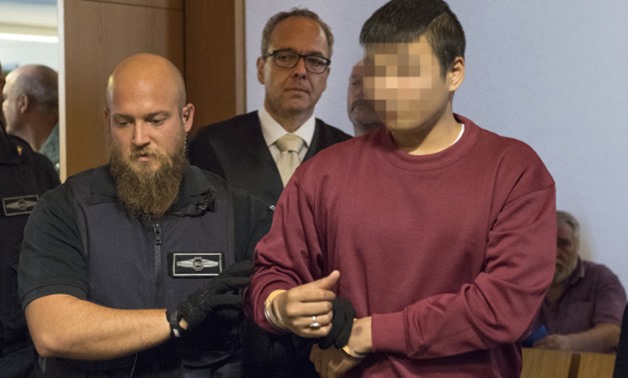 Husseen K. (R), who is accused of raping and killing a young woman in October 2016, and his lawyer Sebastian Glathe (C) enter the court room at the regional court in Freiburg, southern Germany, on Sept 5, 2017. — AFP

