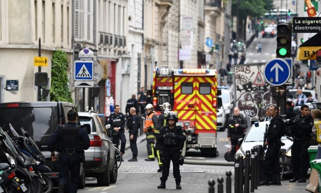 Police officers stand near the site of an ongoing hostage situation in central Paris
