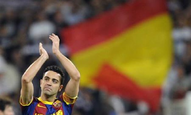 Barcelona's Xavi Hernandez acknowledges supporters after their Spanish first division soccer match against Real Madrid at Santiago Bernabeu stadium in Madrid, April 16, 2011. REUTERS/Felix Ordonez
