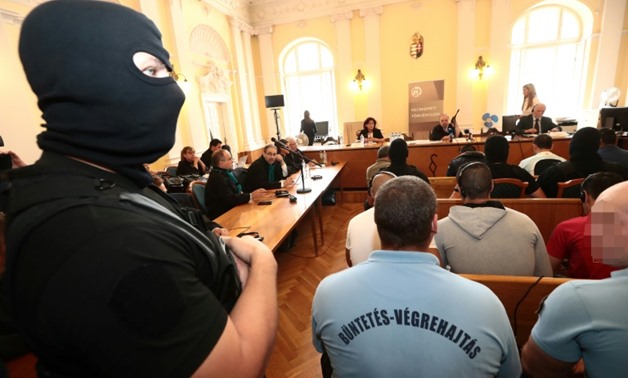 A policeman stands guard in the Hungarian courtroom Thursday as four key suspects are sentenced to 25 years in jail for the gruesome deaths of 71 migrants
