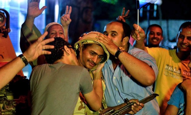Egyptians in Cairo hug and kiss a soldier, on July 3, 2013-AFP/Mohamed El-Shahed