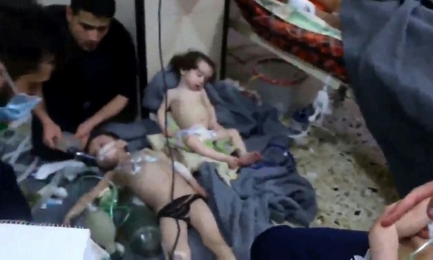 A grab from a video released by the Syrian civil defence in Douma shows volunteers aiding children at a hospital after an alleged chemical attack, denied by Damascus, on the rebel-held town in April
