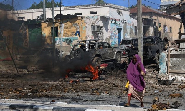 A Somali woman walks past the scene of an explosion near Waberi police station station in Mogadishu, Somalia June 22, 2017. REUTERS/Feisal Omar. “
