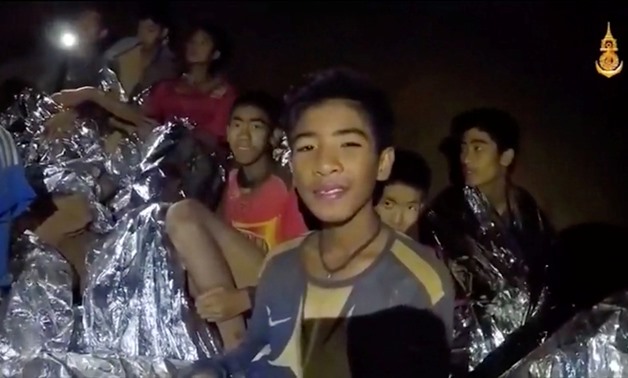 Boys from the under-16 soccer team trapped inside Tham Luang cave covered in hypothermia blankets react to the camera in Chiang Rai, Thailand, in this still image taken from a July 3, 2018 video by Thai Navy Seal. Thai Navy Seal/Handout via REUTERS TV ATT