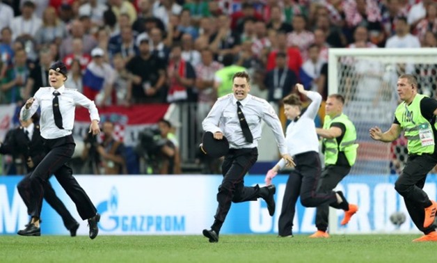 Soccer Football - World Cup - Final - France v Croatia - Luzhniki Stadium, Moscow, Russia - July 15, 2018 Stewards chase pitch invaders REUTERS/Carl Recine
