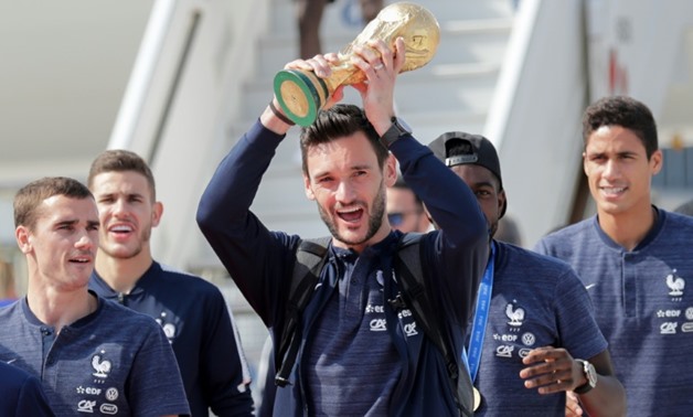 France's goalkeeper Hugo Lloris held up the World Cup after the team's plane landed at Paris' Charles De Gaulle airport on Monday - AFP / Thomas SAMSON
